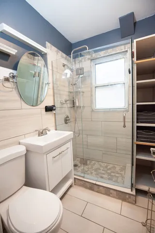 a bathroom with a sink a toilet and shower