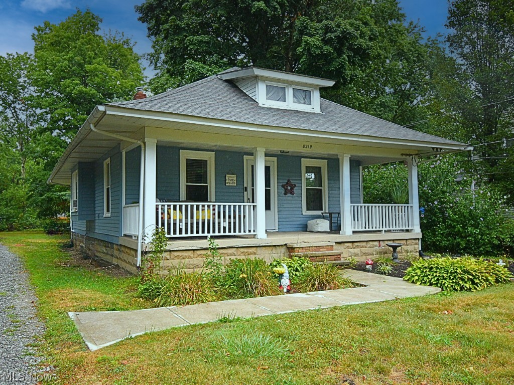 View of front of property featuring a 2 car garage, covered porch and front yard