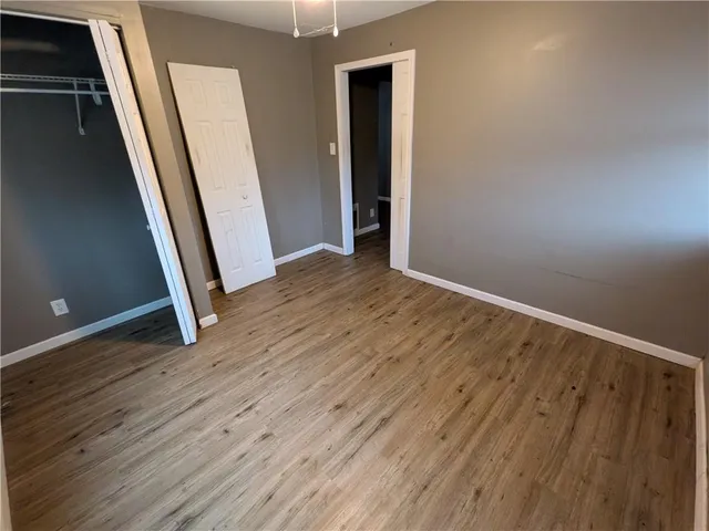 an empty room with wooden floor and entrance