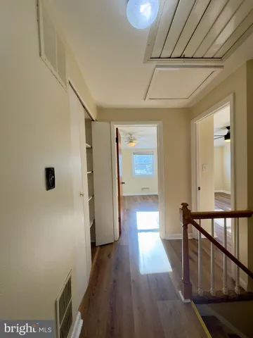 a view of a hallway with wooden floor and staircase