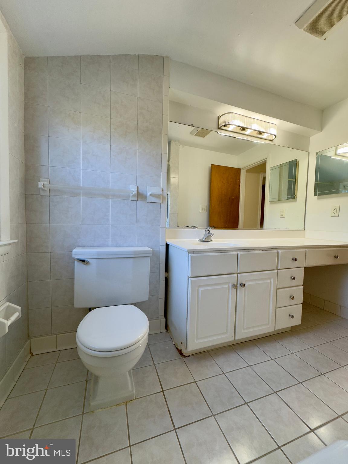 1011 Linden Avenue Baltimore, MD 21227 - Photo 5 of 20 a bathroom with a toilet a sink and mirror