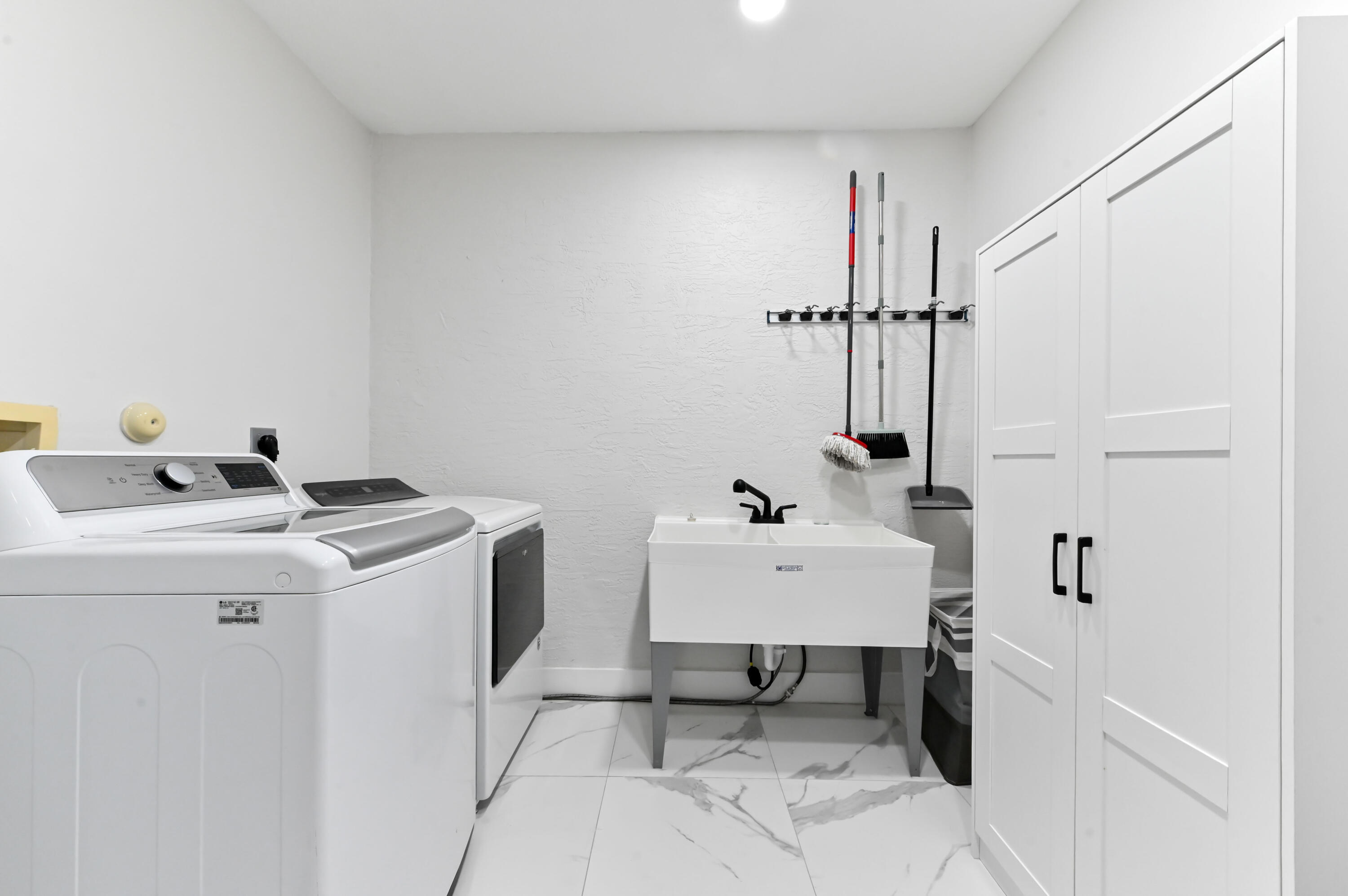 6880 Brook Hollow Road Lake Worth, FL 33467 - Photo 23 of 31 a view of storage and utility room with washer and dryer