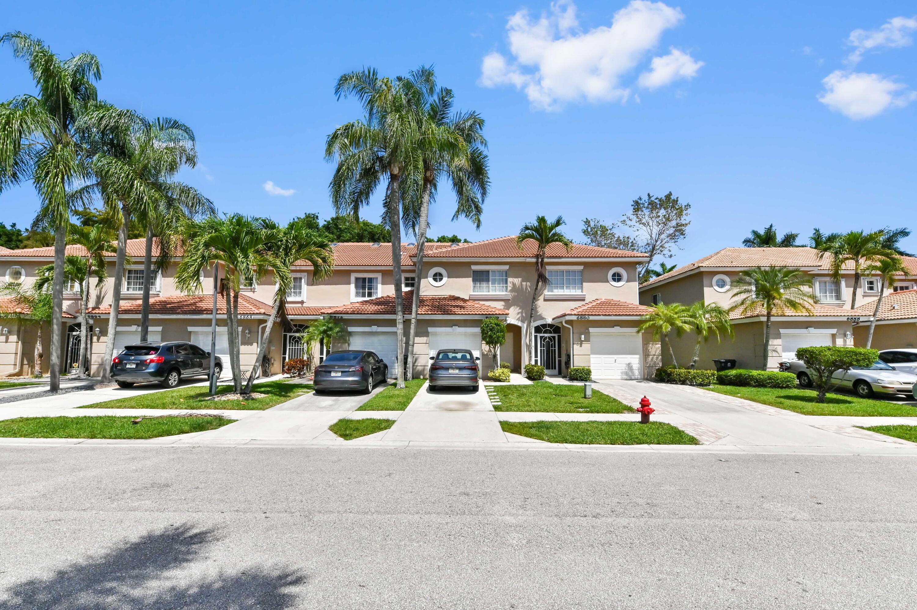 6880 Brook Hollow Road Lake Worth, FL 33467 - Photo 24 of 31 a view of a building with a yard and palm trees