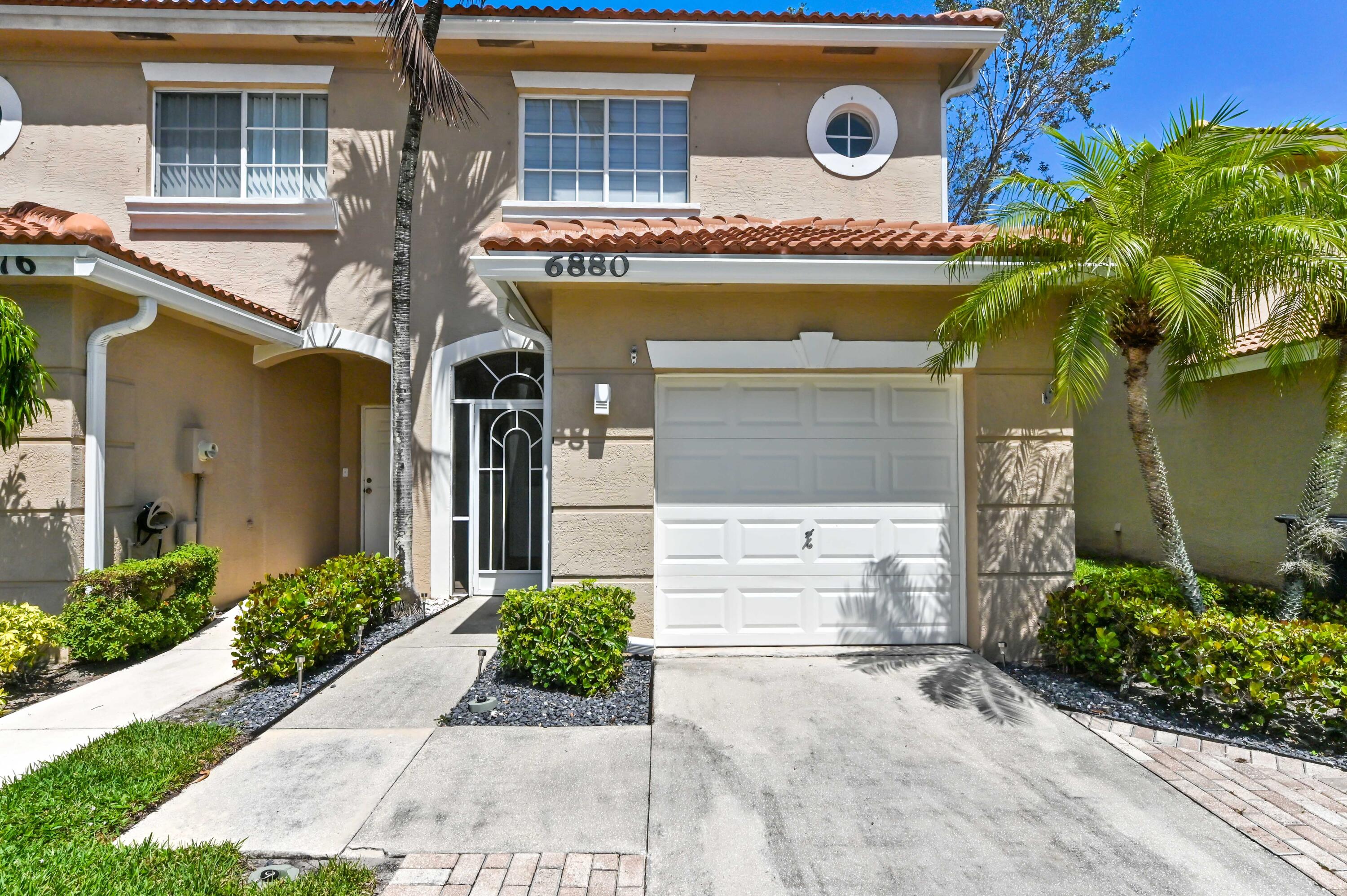 6880 Brook Hollow Road Lake Worth, FL 33467 - Photo 25 of 31 a front view of a house with garden