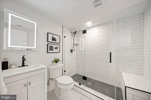 a bathroom with a sink a toilet and shower