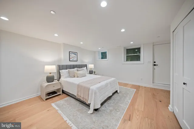 a spacious bedroom with a bed and a wooden floor