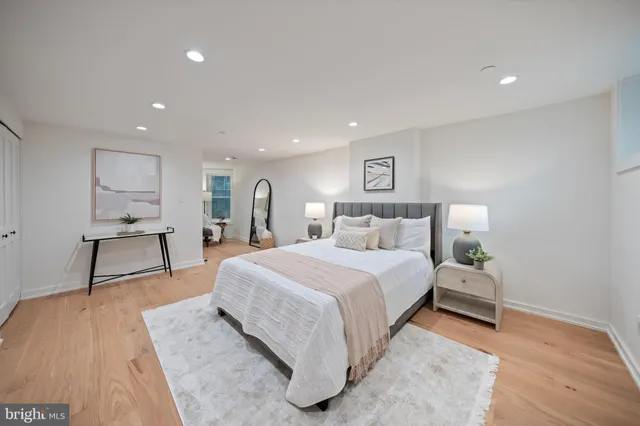 a spacious bedroom with a bed and a lamp