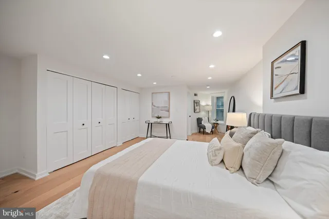 a large bedroom with a bed and a painting on the wall