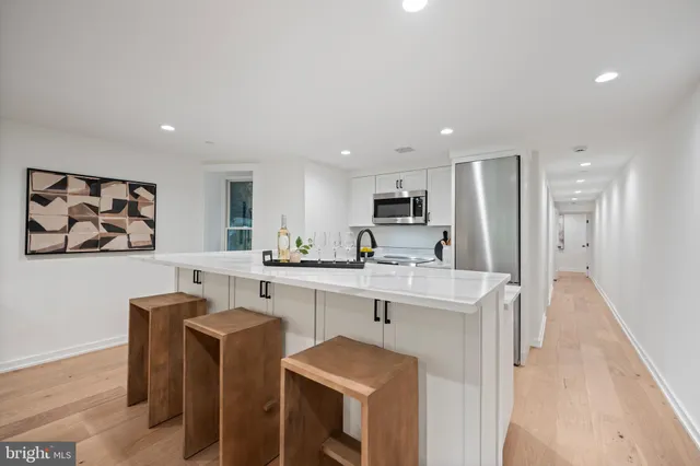 a kitchen with stainless steel appliances granite countertop a sink a stove a refrigerator with white cabinets