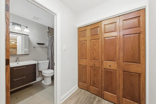 a bathroom with a granite countertop sink mirror vanity and toilet