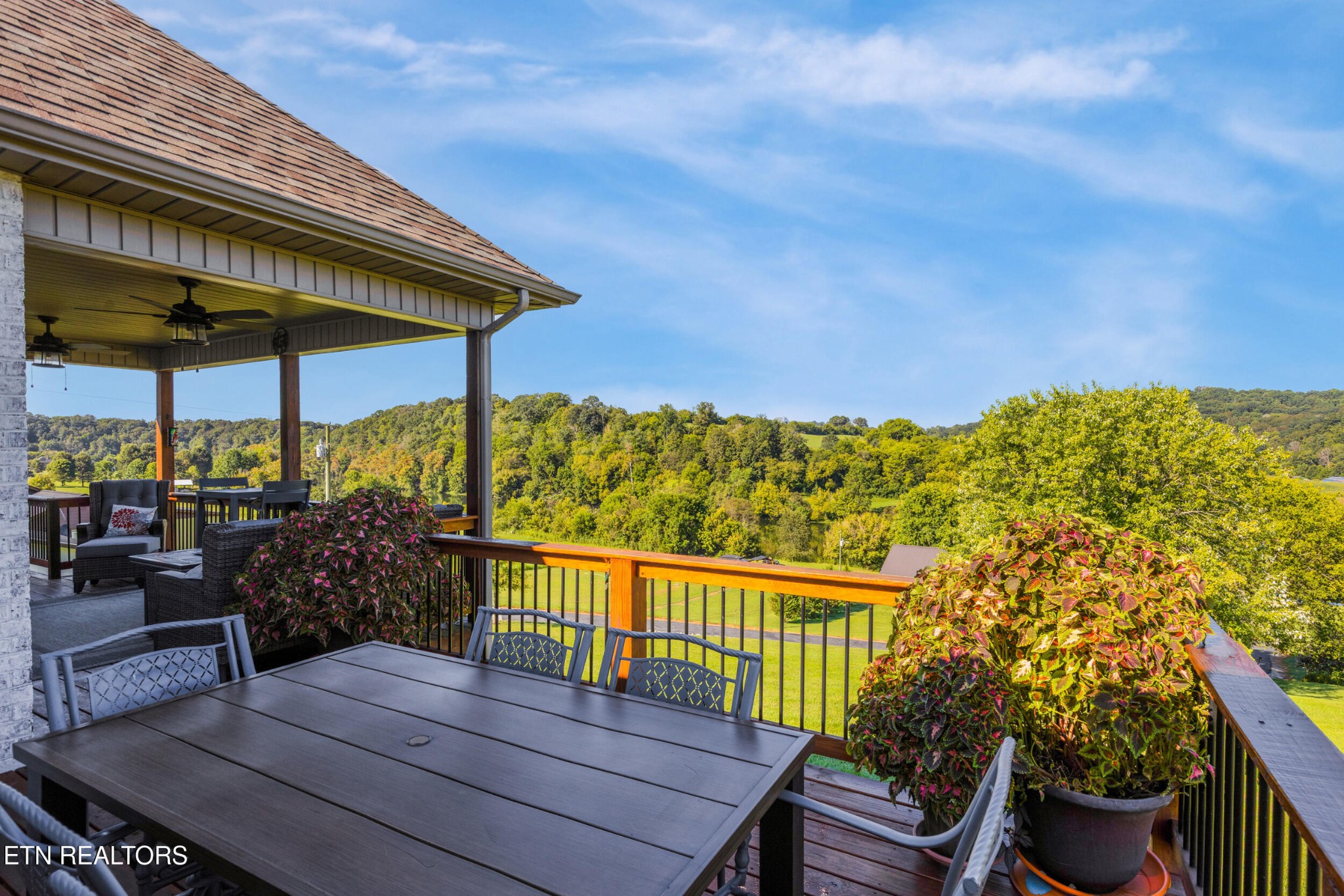 1866 Holston River Drive Rutledge, TN 37861 - Photo 27 of 54 a view of a roof deck with a dining table and chairs under an umbrella