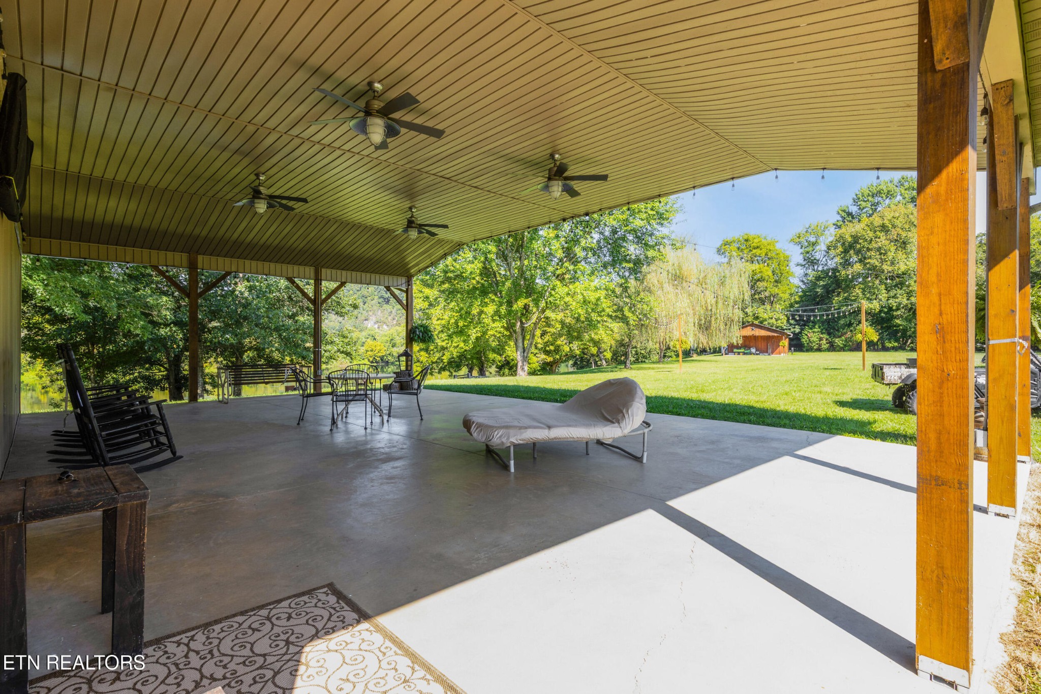 1866 Holston River Drive Rutledge, TN 37861 - Photo 42 of 54 a view of a patio with table and chairs under an umbrella with a small yard