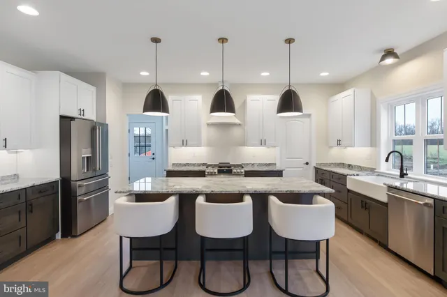 a kitchen with granite countertop a stove a sink a dining table and chairs