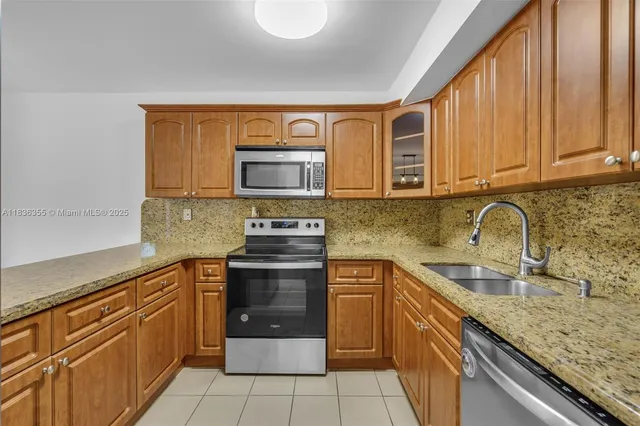 a kitchen with stainless steel appliances granite countertop a sink stove and microwave