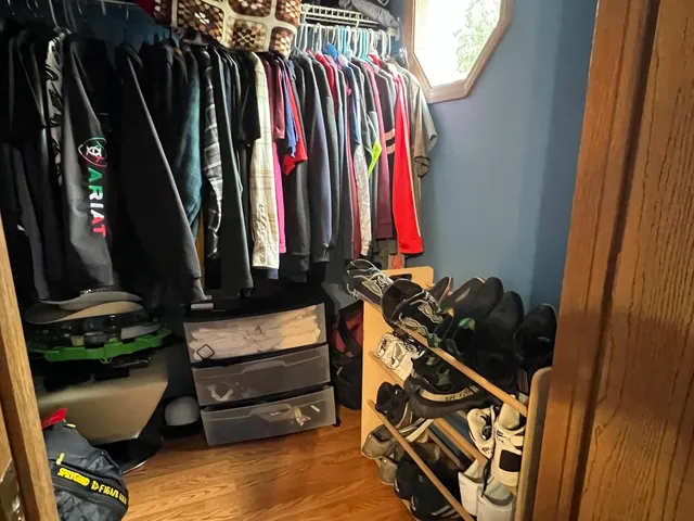 a view of walk in closet with clothes and shoes