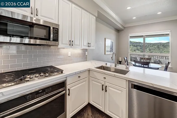 a kitchen with stainless steel appliances a sink stove and microwave