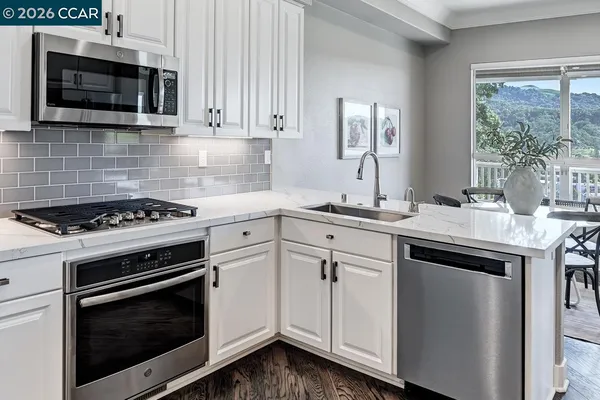 a large kitchen with stainless steel appliances granite countertop a refrigerator and a stove top oven