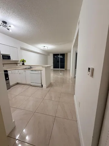 a kitchen with a refrigerator and white cabinets