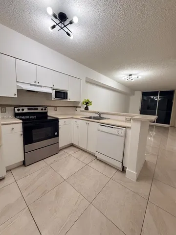 a kitchen with cabinets and white stainless steel appliances