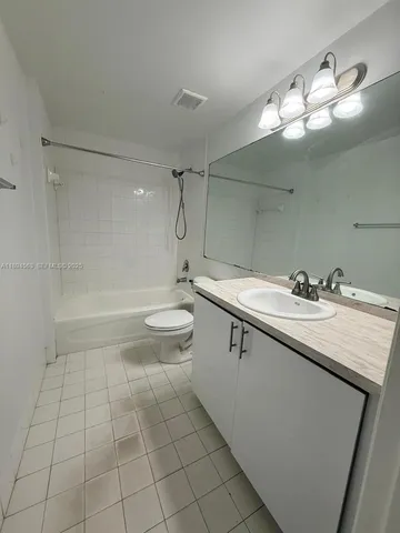 a view of an empty room and chandelier fan