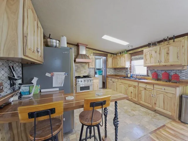 a kitchen with granite countertop a sink cabinets and stove top oven