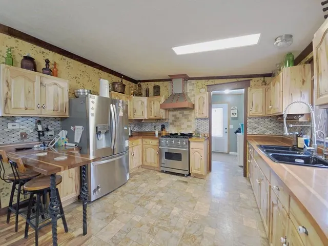 a kitchen with stainless steel appliances a stove a sink cabinets and a refrigerator