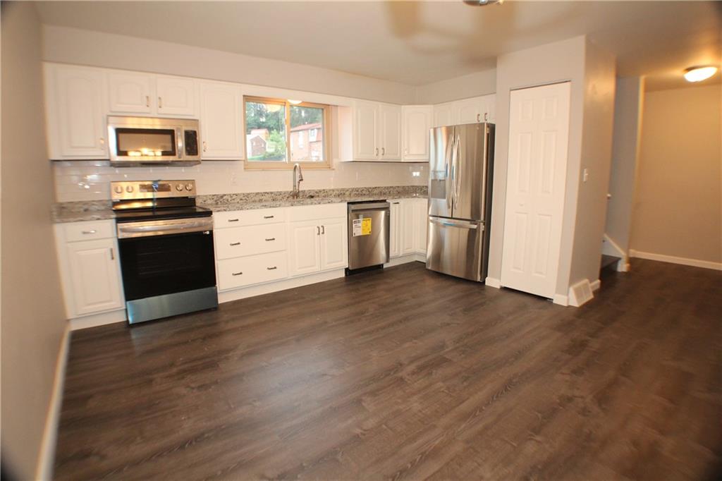 8112 A Nuttals Grove Road Pittsburgh, PA 15239 - Photo 6 of 20 a kitchen with a refrigerator stove and wooden floor