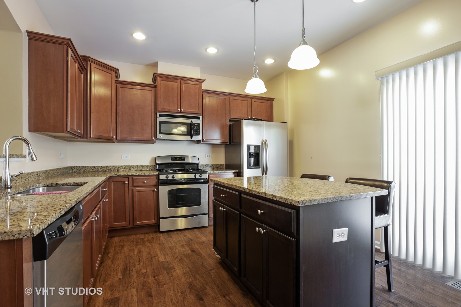 6826 Prairie Street Morton Grove, IL 60053 - Photo 3 of 16 a kitchen with stainless steel appliances granite countertop wooden cabinets a stove a sink and a refrigerator