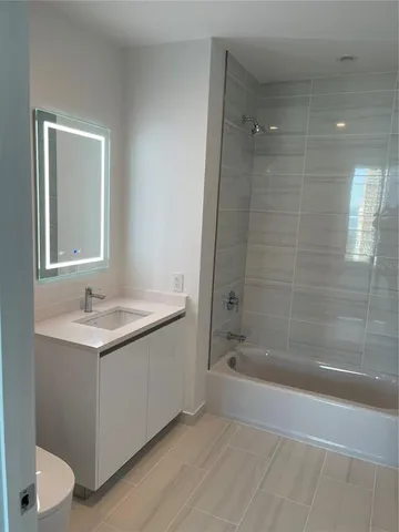 a bathroom with a granite countertop sink a toilet and shower