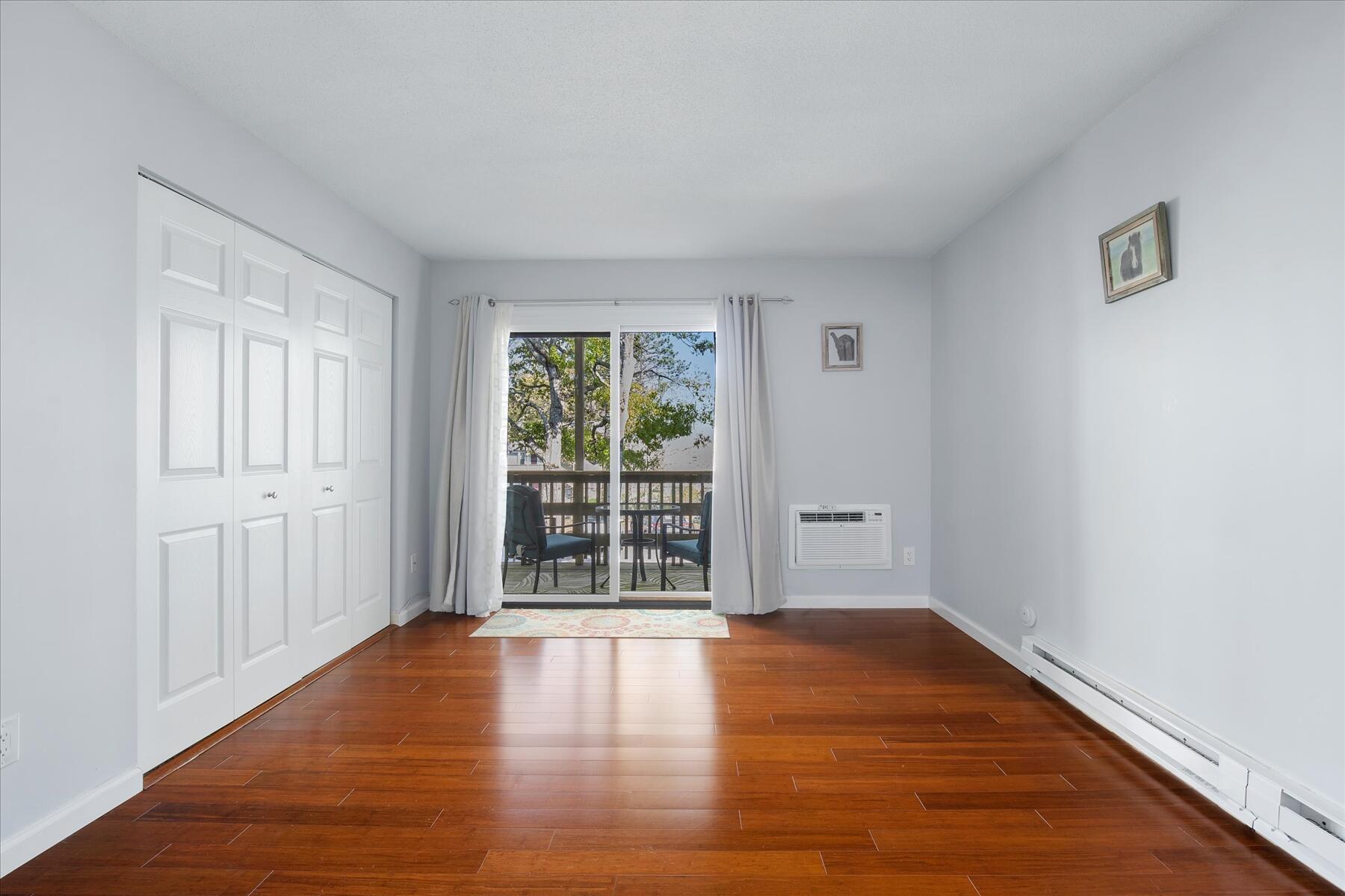 800 Bearses Way, Unit 1EB Hyannis, MA 02601 - Photo 21 of 37 an empty room with wooden floor and windows