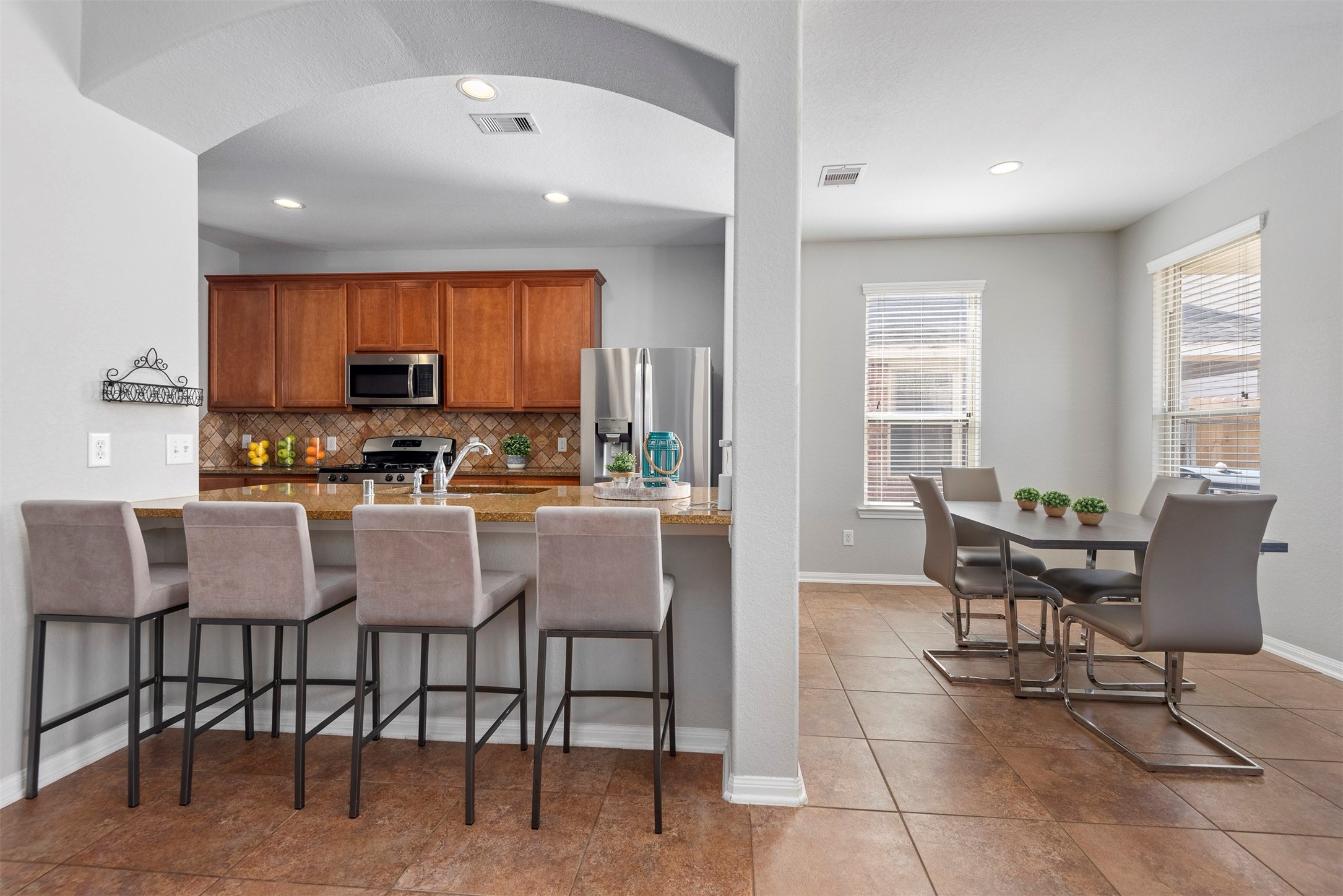 6211 Flagg Ranch Drive Spring, TX 77388 - Photo 17 of 36 Spacious breakfast bar with seating opens seamlessly to the kitchen, perfect for casual dining and entertaining. Functional layout offers both comfort and convenience.
