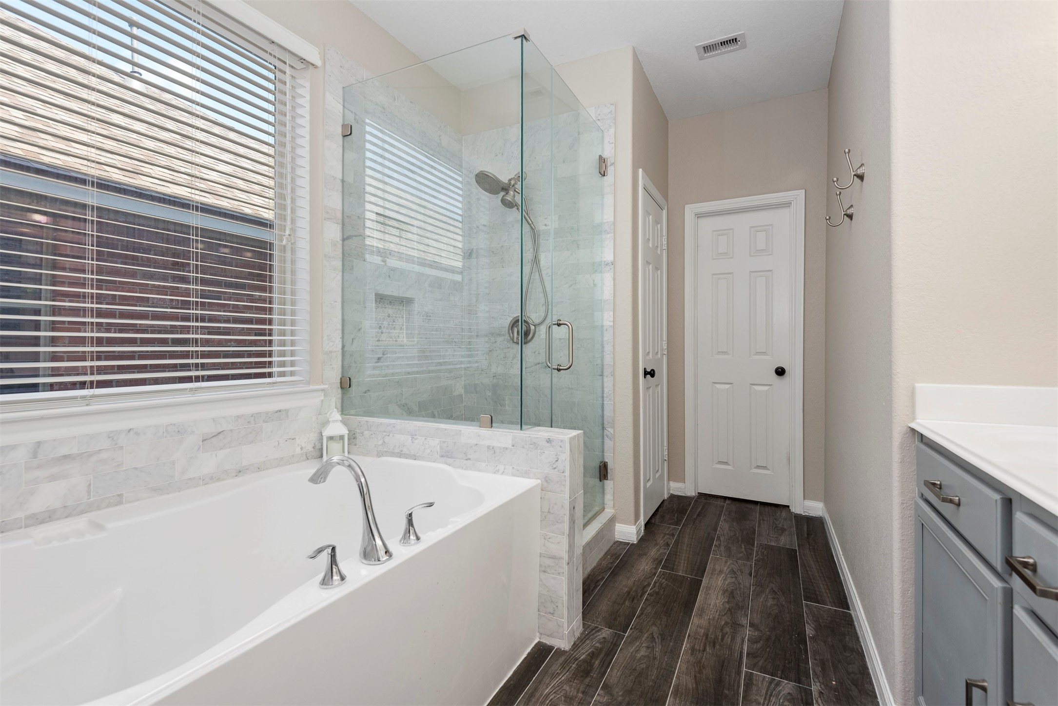 6211 Flagg Ranch Drive Spring, TX 77388 - Photo 26 of 36 Spa-like primary bath with soaking tub and separate glass-enclosed shower, perfect for relaxing after a long day. Generous walk-in closet provides plenty of storage and organization space.