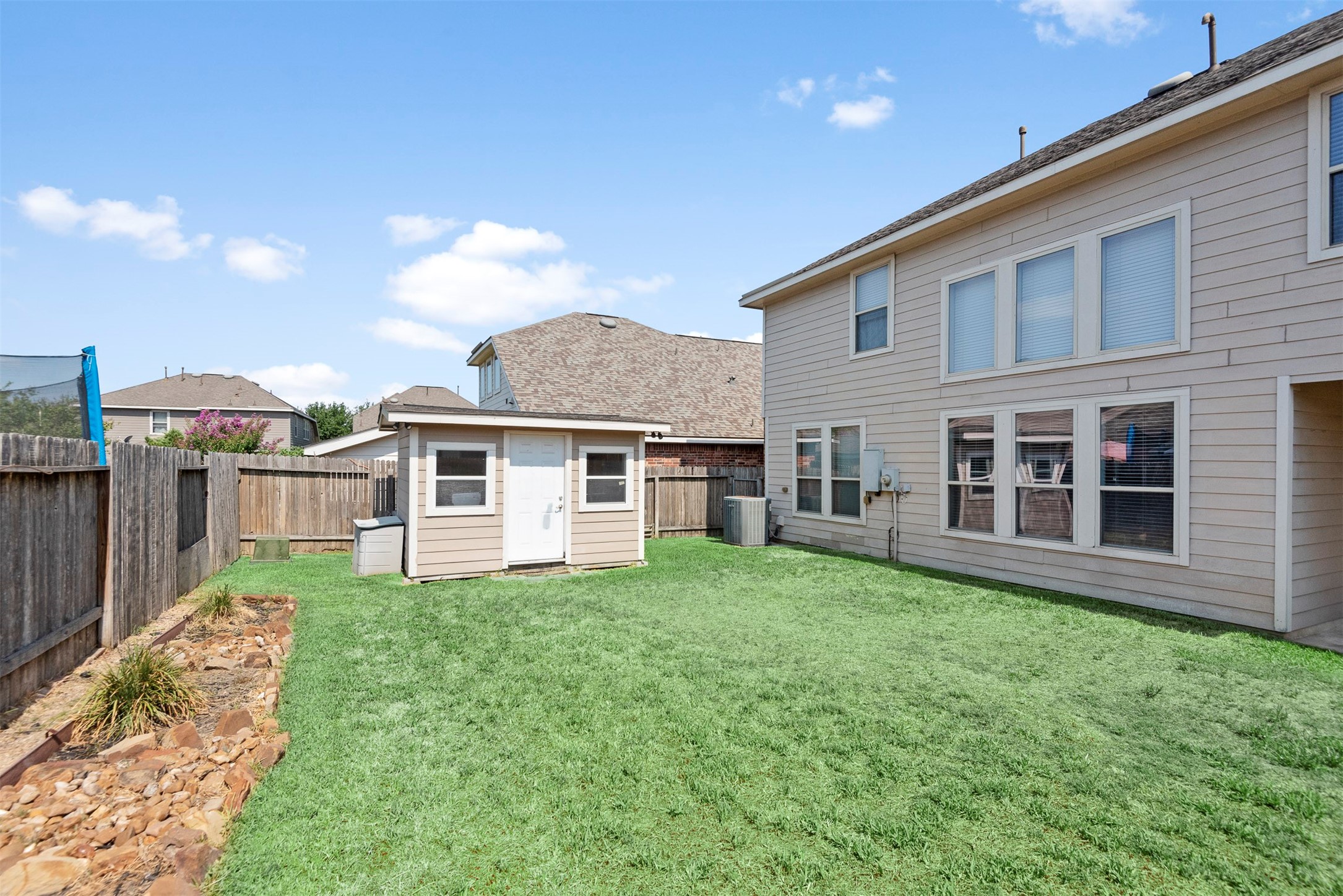6211 Flagg Ranch Drive Spring, TX 77388 - Photo 35 of 36 Generous backyard featuring a storage shed and ample green space, perfect for everyday use or additional storage needs.