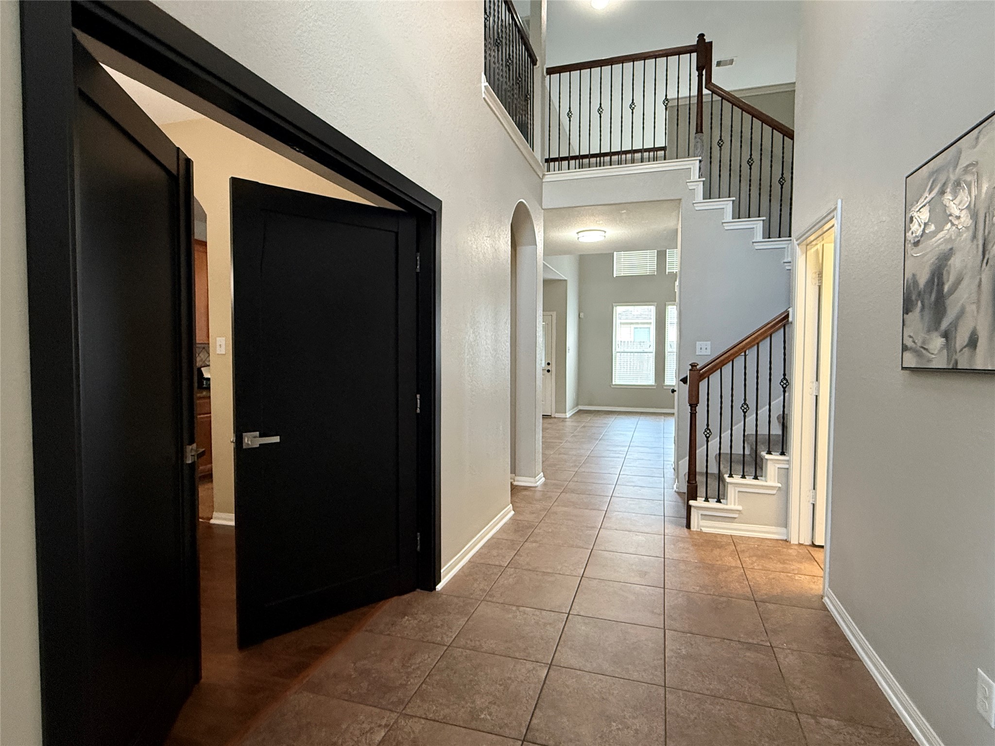 6211 Flagg Ranch Drive Spring, TX 77388 - Photo 6 of 36 Inviting two-story foyer with tile flooring, soaring ceilings, and elegant staircase featuring iron balusters. The space offers a bright, open feel and seamless flow into the main living areas.