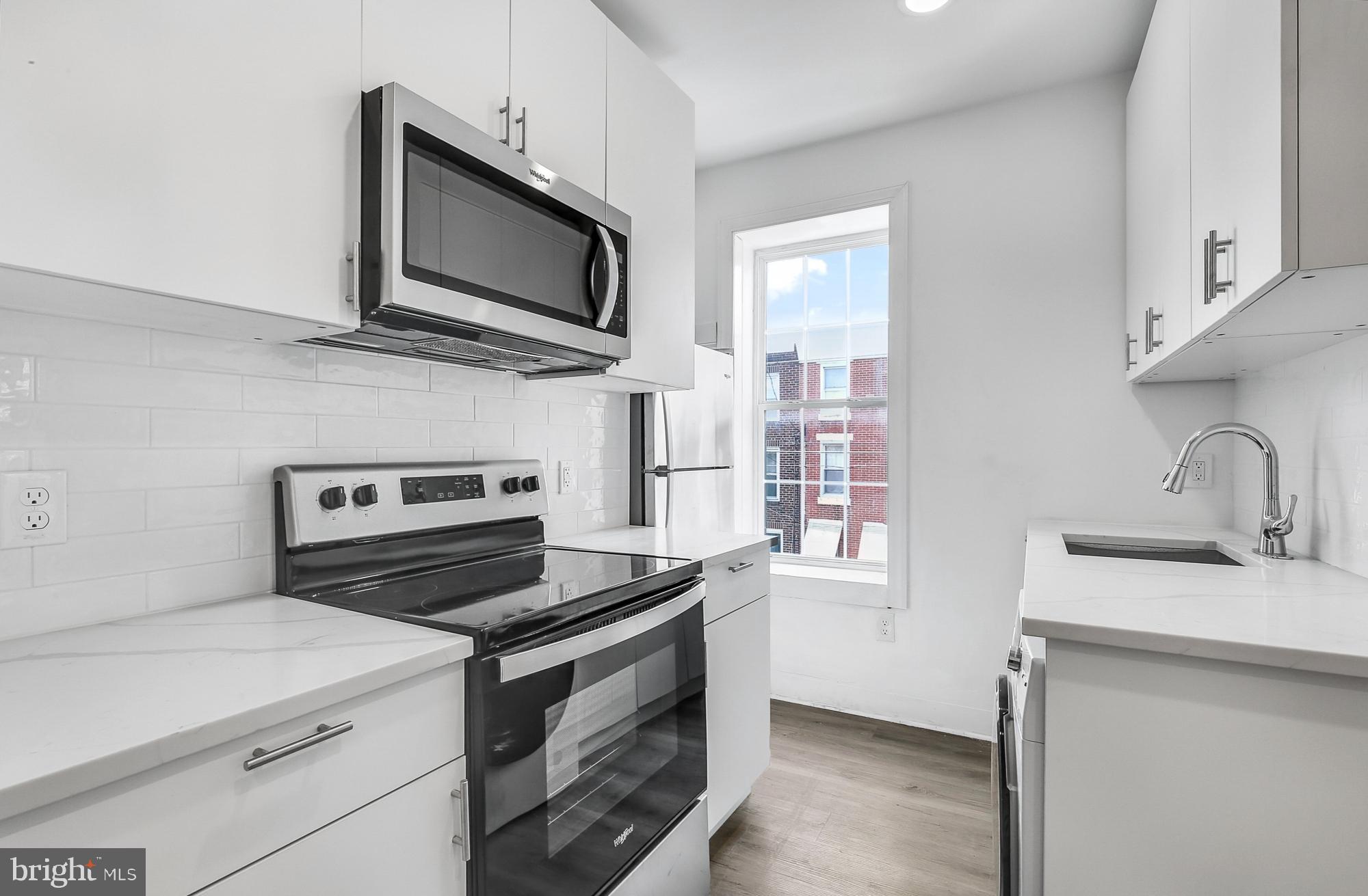 2046 East Huntingdon Street, Unit 2F Philadelphia, PA 19125 - Photo 2 of 15 a kitchen with a stove and a microwave