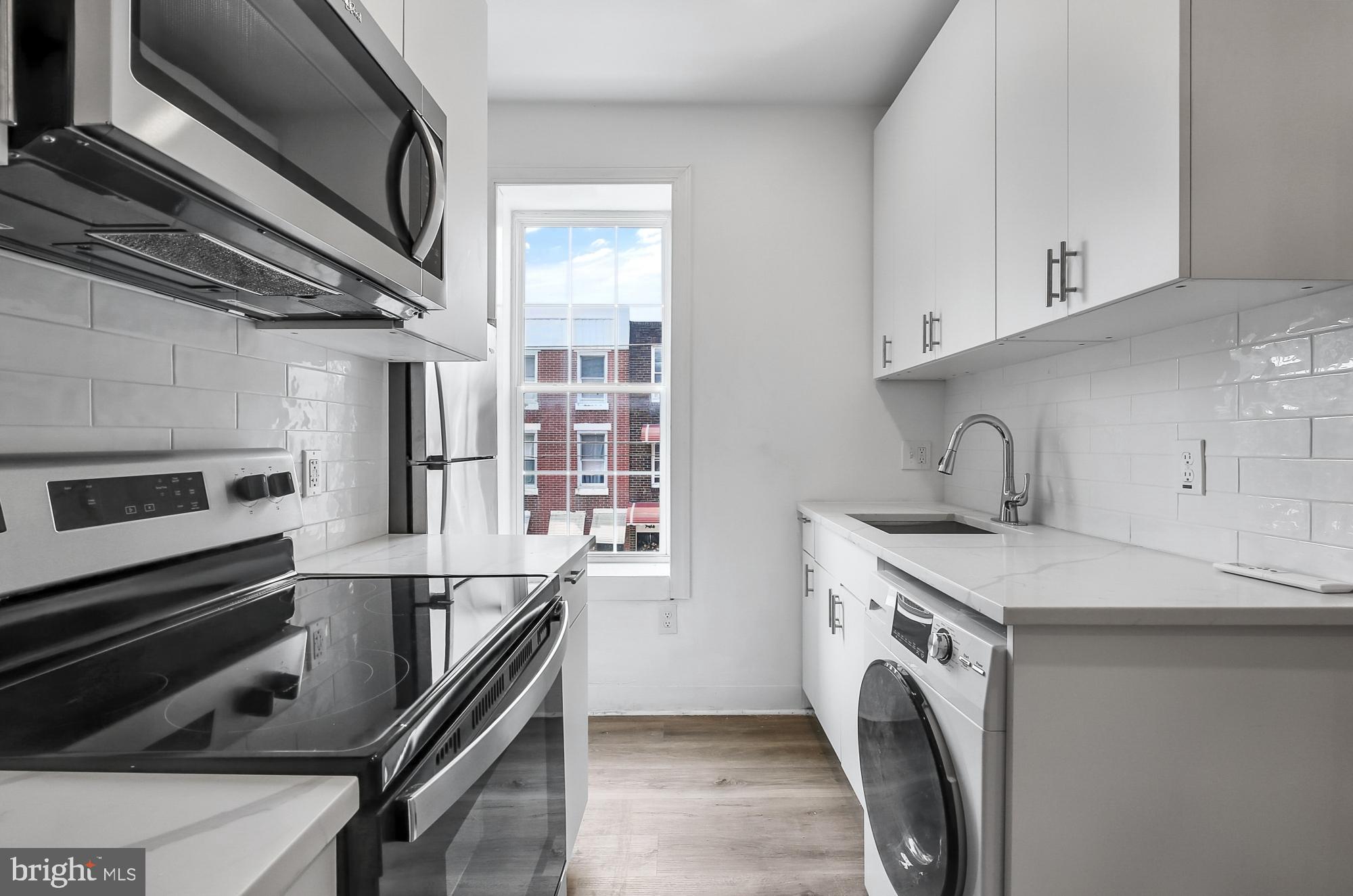 2046 East Huntingdon Street, Unit 2F Philadelphia, PA 19125 - Photo 4 of 15 a kitchen with stainless steel appliances a stove microwave and sink