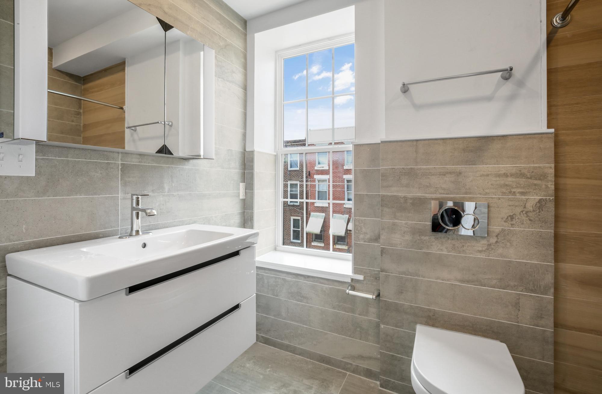 2046 East Huntingdon Street, Unit 2F Philadelphia, PA 19125 - Photo 7 of 15 a bathroom with a sink a toilet and mirror