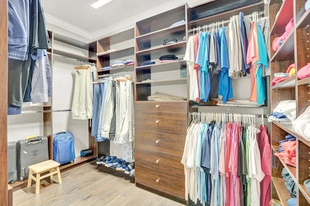 a view of walk in closet with clothes and shoes
