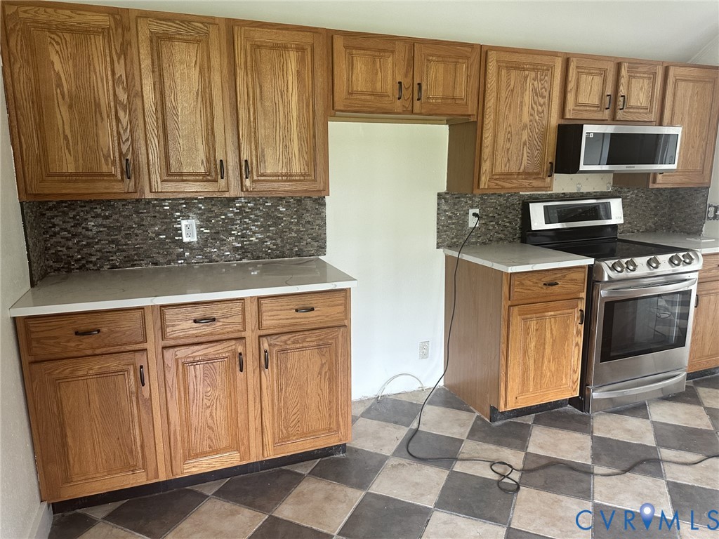 803 Beach Road Hampton, VA 23664 - Photo 17 of 43 a kitchen with granite countertop a stove top oven microwave and cabinets