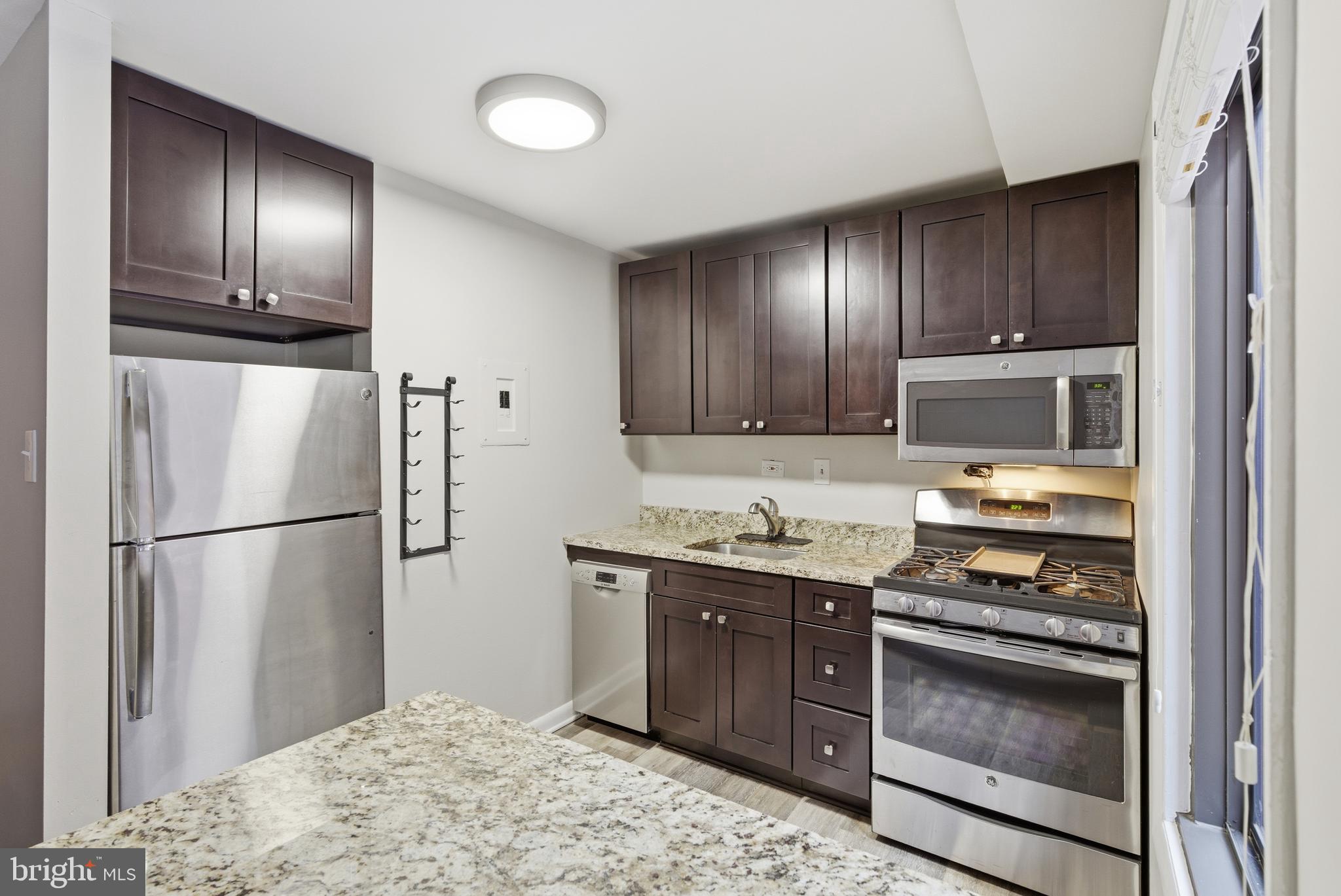 1440 Northwest N Street Northwest, Unit 404 Washington, DC 20005 - Photo 15 of 24 a kitchen with granite countertop stainless steel appliances and wooden cabinets