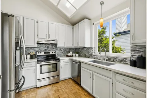 a kitchen with a sink stove and white cabinets