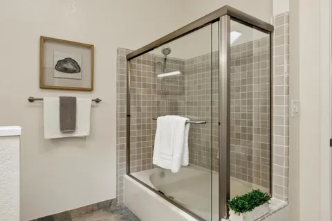 a bathroom with a granite countertop sink mirror and shower