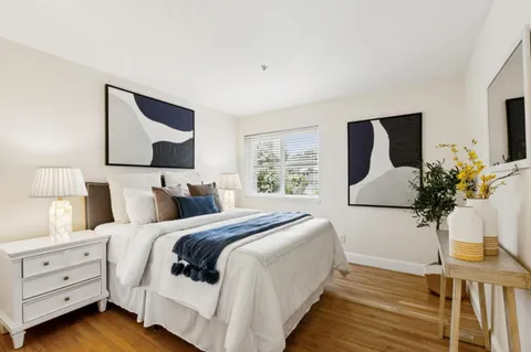 a living room with a bed and a lamp with the dresser