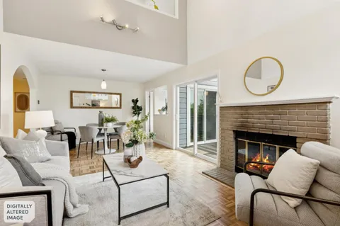 a living room with furniture a fireplace and a chandelier