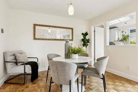a view of a dining room with furniture and a potted plant
