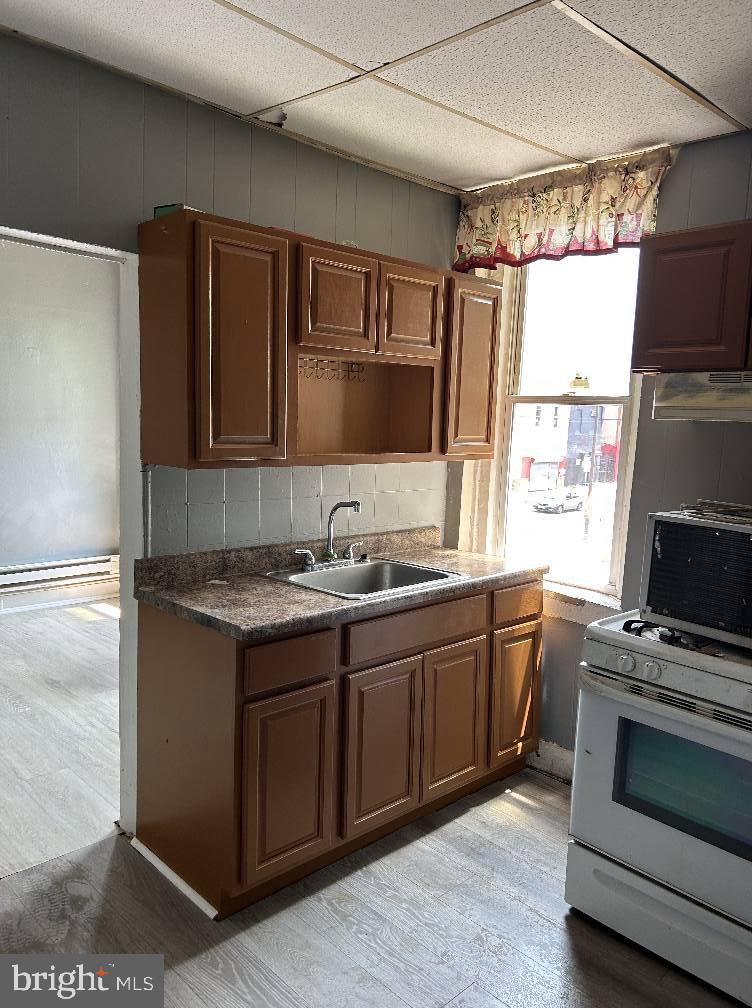 3612 North 5th Street Philadelphia, PA 19140 - Photo 2 of 9 a kitchen with stainless steel appliances granite countertop a sink stove and refrigerator