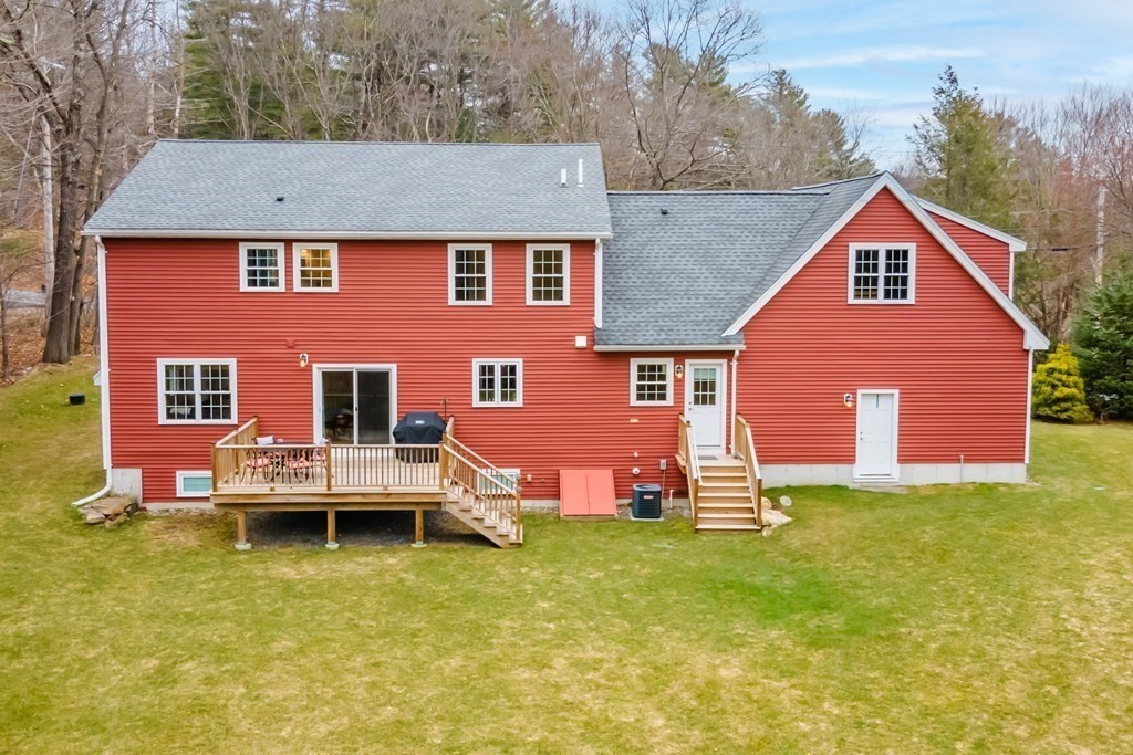 32 Harvard Road Bolton, MA 01740 - Photo 32 of 35 a front view of house with yard and trees in the background