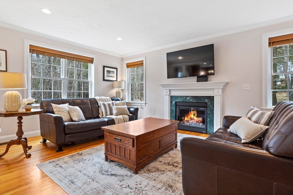 32 Harvard Road Bolton, MA 01740 - Photo 8 of 35 a living room with furniture flat screen tv and a fireplace
