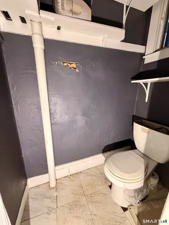 a white toilet sitting next to a shower