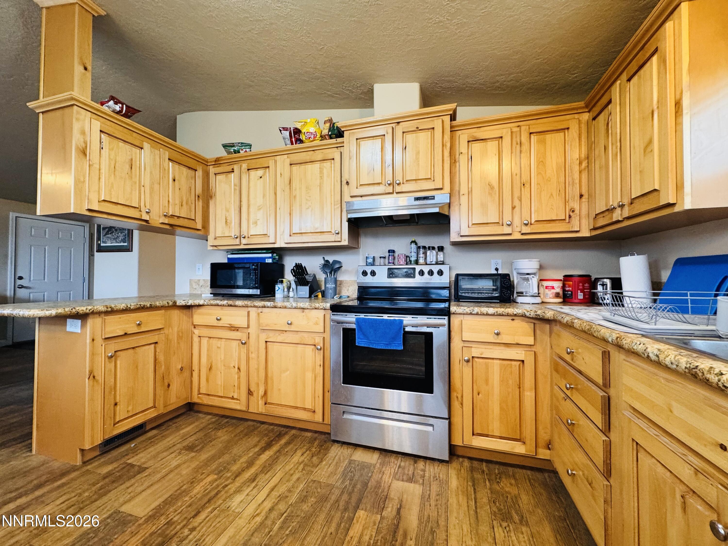 29400 Kings River Road Orovada, NV 89425 - Photo 17 of 40 a kitchen with stainless steel appliances granite countertop a stove a sink and a refrigerator